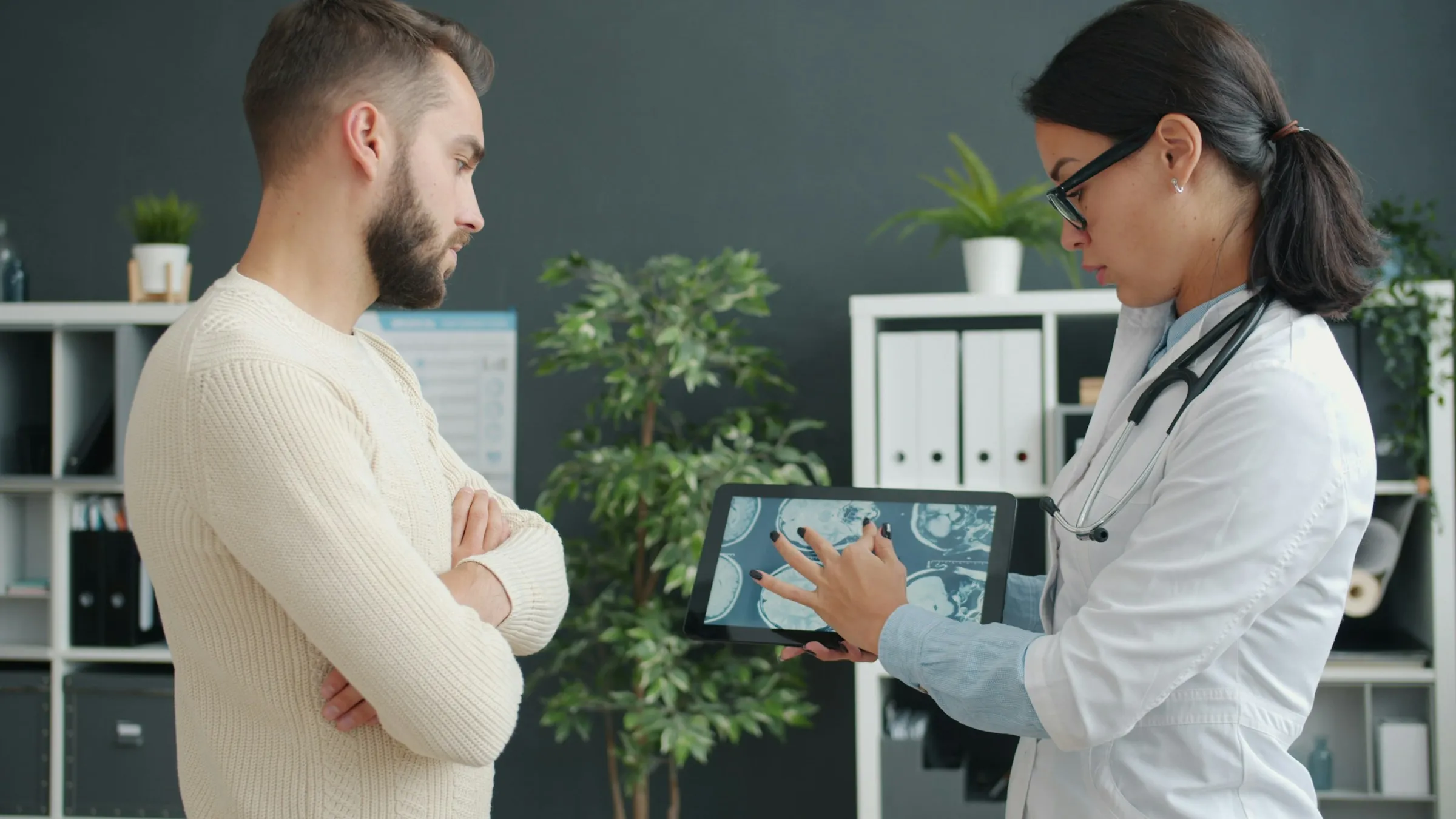 A doctor showing a patient a scan on a tablet.